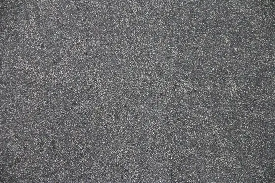 Close-up of grey mineral-surfaced roofing felt, the finish on many older garage and extension flat roofs