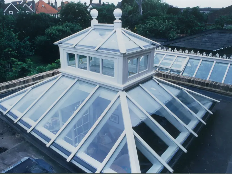 Flat roof on a house extension with a white timber roof lantern set into it and brick upstands around the edge