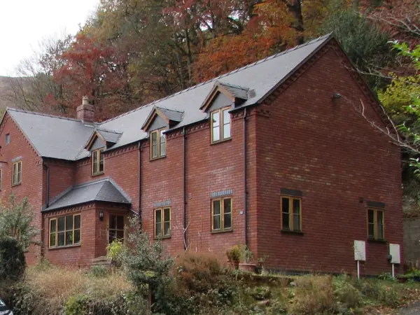 Brick house with a neat, unbroken slate roof, straight courses and three slate-roofed dormers