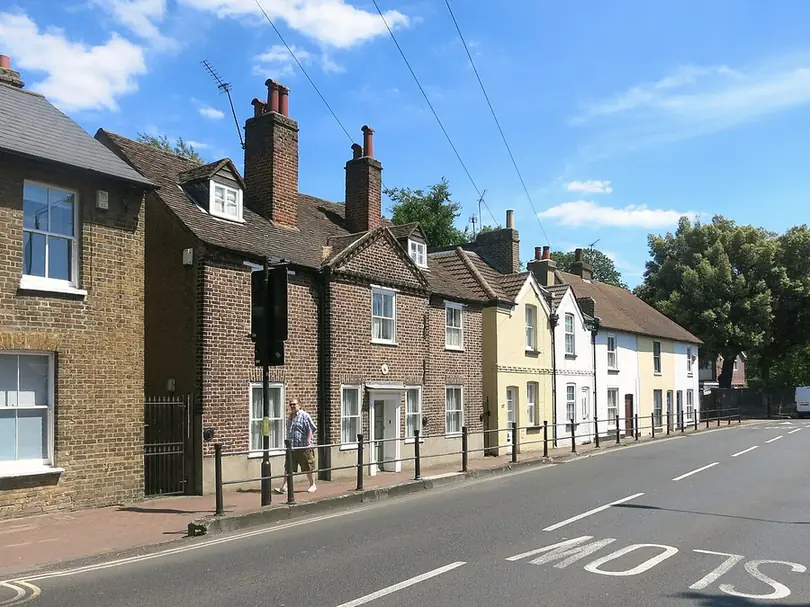 Row of brick and painted cottages with tall chimney stacks on Bexley High Street, Old Bexley