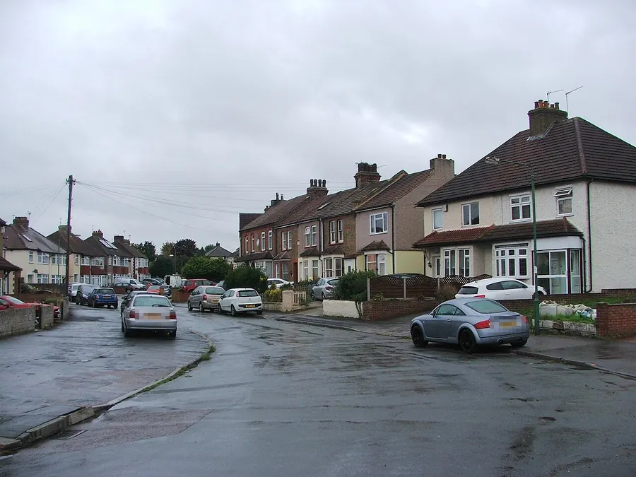 Semi-detached and terraced houses with tiled roofs and chimneys on Hedge Place Road, Stone