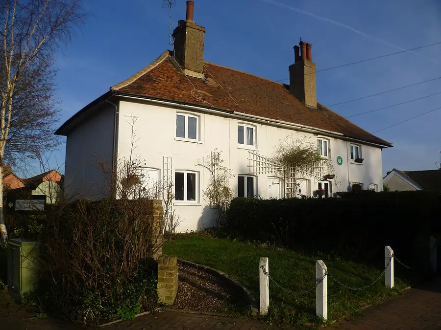 Old white-painted cottage with a clay-tiled roof and twin chimneys on Prospect Row, Swanley Village